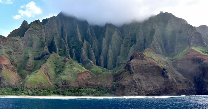 Zelené útesy Na Pali Coast na Kauai padající do oceánu